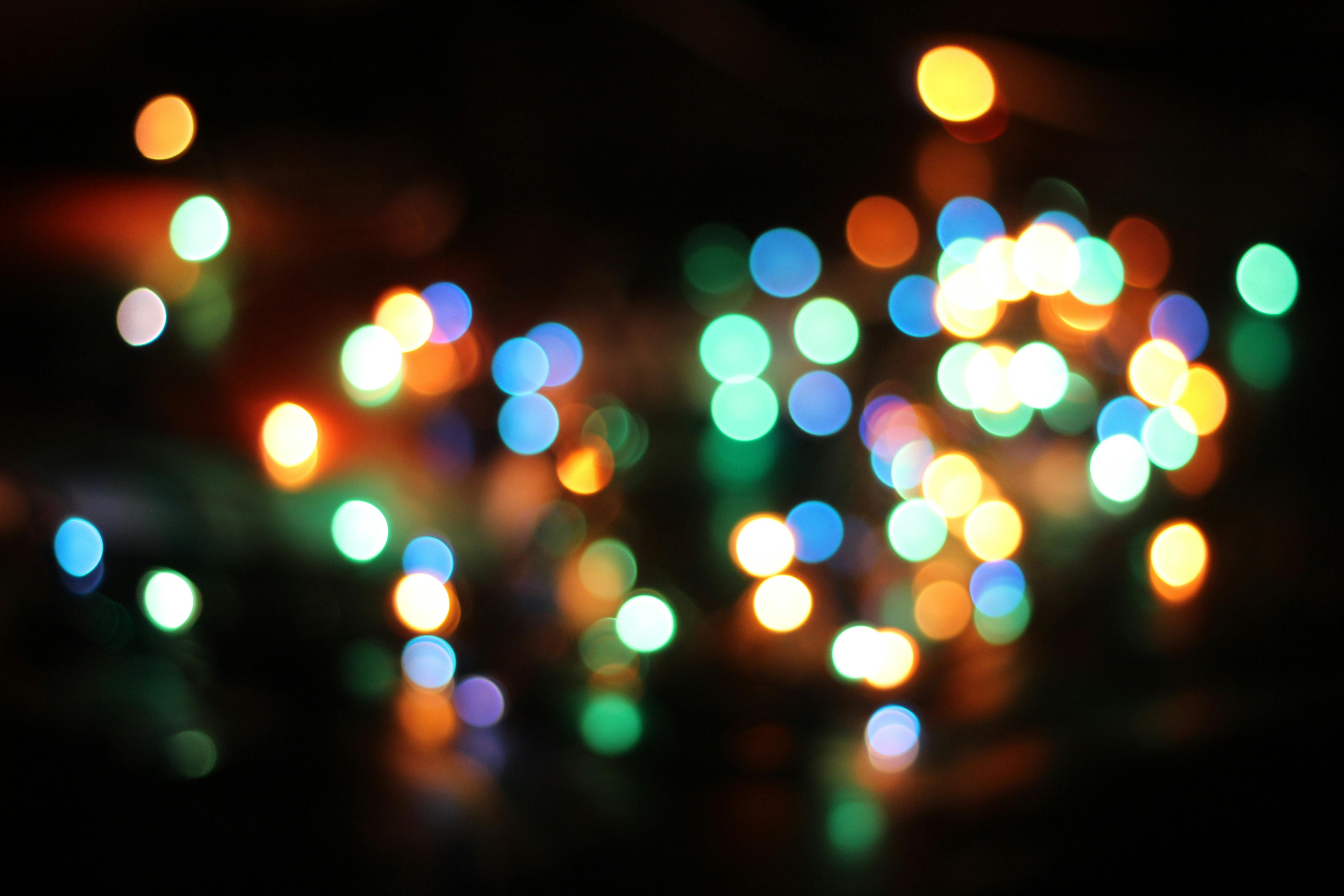 Bunte, verschwommene Lichtpunkte vor schwarzem Hintergrund.