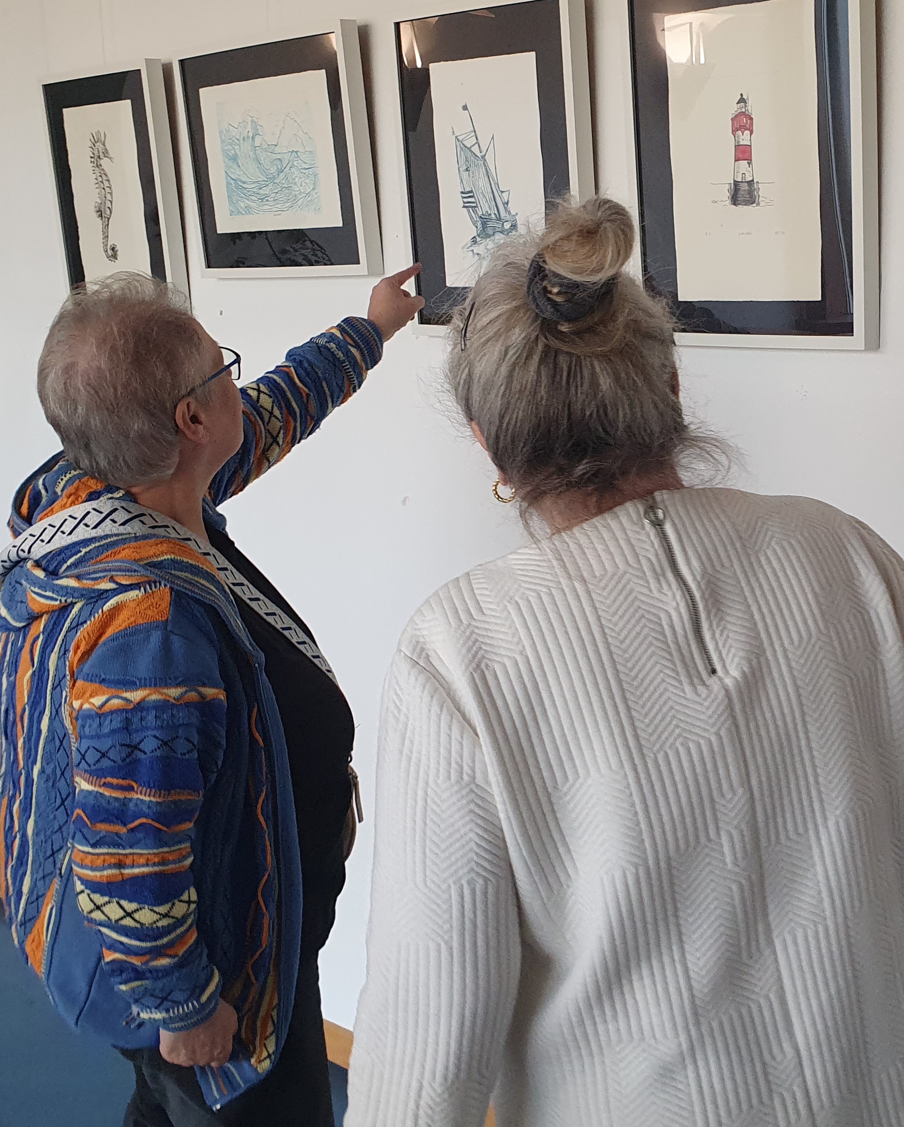 Ein Seepferdchen, eine Welle, ein Schiff, ein Leuchtturm sind unter anderem im offenen Atelier entstanden. Zwei ältere Frauen stehen vor den Werken uns sprechen darüber.